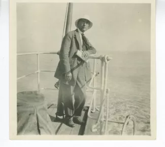 photographie d'André Gide, accoudé sur le pont du bateau qui l'emmène en Corse avec André Allégret et Élisabeth Van Rysselberghe, août 1923