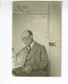 photographie d’André Gide, assis, lisant près d’une porte, à l'hôtel Maritima, printemps 1925