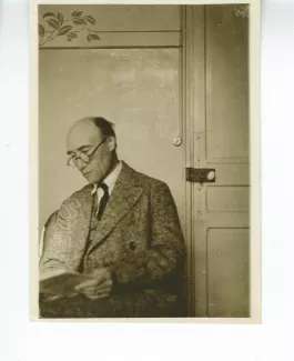 photographie d’André Gide, assis, lisant près d’une porte, à l'hôtel Maritima, printemps 1925