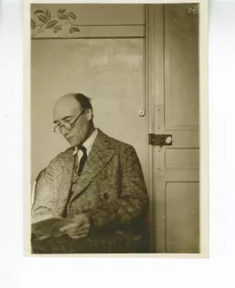 photographie d’André Gide, assis, lisant près d’une porte, à l'hôtel Maritima, printemps 1925
