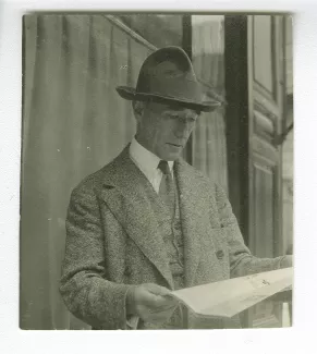 photographie d’André Gide, avec chapeau, lisant un journal dehors, juillet 1925