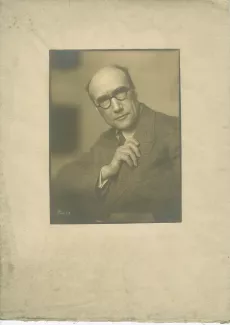 portrait photographique d’André Gide, avec lunettes, de face et la main droite sur le revers de son costume