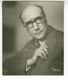 portrait photographique d’André Gide, avec lunettes, de face et la main droite sur le revers de son costume