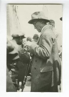 photographie d’André Gide, de profil, avec chapeau, au milieu d'une foule, automne 1929