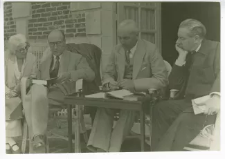 photographie montrant, de gauche à droite, Maria Van Rysselberghe, André Gide, un livre à la main, Marcel de Coppet, lisant à haute voix, et Roger Martin du Gard, travaillant à la traduction de Old Wives' Tale d'Arnold Bennett, au château du Tertre, la pr