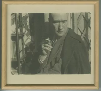 portrait photographique d’André Gide, de face, la tête penchée, fumant, février 1925