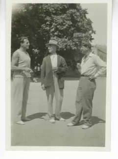 photographie d’André Gide, avec chapeau, fumant, entouré du boxeur Billy Balzac, à gauche, et de Sam Quinchon, à droite, 30 août 1930