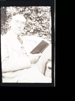 portrait photographique d'André Gide, de face, tête inclinée vers la droite, un livre dans la main droite, mai 1930