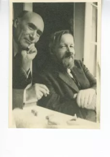 photographie d'André Gide, fumant, main gauche sur la joue, et Bernard Groethuysen, cigarette en bouche, tous deux souriant, juillet 1931