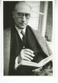 portrait photographique d'André Gide, presque de face, avec lunettes, lisant, cigarette dans la main droite, juillet 1931