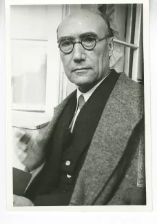 portrait photographique en buste d'André Gide, regardant l'objectif, avec lunettes, main droite floue, juillet 1931