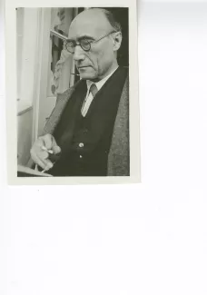 portrait photographique en buste d'André Gide, de ¾ gauche, avec lunettes, lisant et fumant, juillet 1931