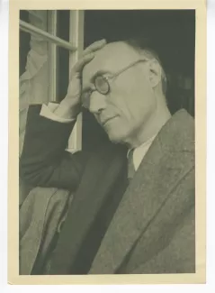 portrait photographique en buste d'André Gide, de ¾ gauche, avec lunettes, la main droite sur le front, juillet 1931