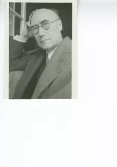 portrait photographique en buste d'André Gide, avec lunettes, la main droite sur le crâne, regardant l'objectif, juillet 1931