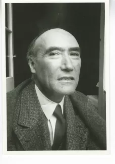 portrait photographique en buste d'André Gide, presque de face, regarde l’objectif avec un sourire forcé, juillet 1931