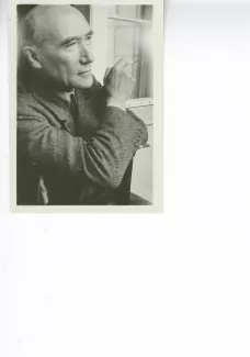 portrait photographique en buste d'André Gide, de ¾ droite, regardant devant lui, cigarette dans la main droite, à califourchon sur une chaise, juillet 1931