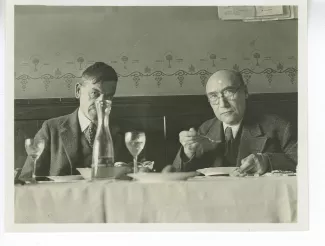 photographie d’André Gide, cuillère à la main, et Charles-Ferdinand Ramuz, lors d’un déjeuner, décembre 1933