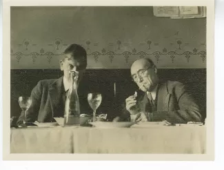 photographie d’André Gide, allumant une cigarette, et Charles-Ferdinand Ramuz, lors d’un déjeuner à La Crochette, 9 décembre 1933