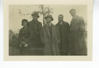 photographie de groupe montrant André Gide, avec lunettes et chapeau, et quatre Bellettriens, dont Ferdinande et Alfred Wild (à gauche de Gide), et Pierre Beausire (premier à droite de Gide), en extérieur, décembre 1933