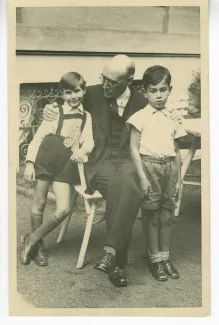 photographie d’André Gide, tenant deux enfants par les épaules, dont un est le fils de Mme Rainer, août 1934