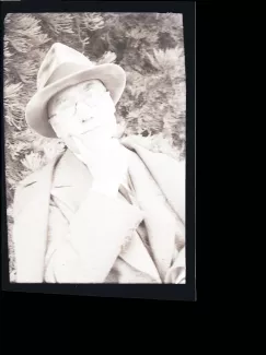 portrait photographique en buste d'André Gide, avec lunettes et chapeau, de face, la main droite sur le menton, songeur, août 1934