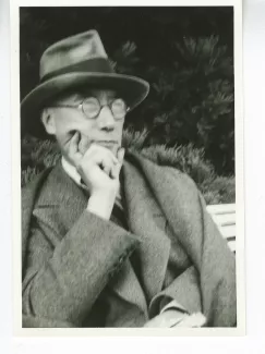 portrait photographique en buste d'André Gide, avec lunettes et chapeau,de ¾ à droite, la main droite sur le menton, août 1934