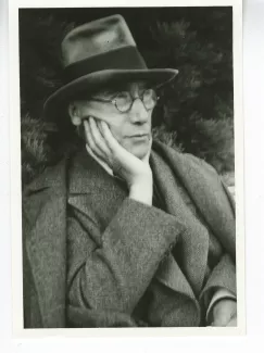 portrait photographique en buste d'André Gide, avec lunettes et chapeau,de ¾ à droite, la main droite sous le menton, août 1934