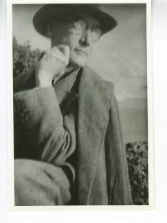 portrait photographique d'André Gide, avec lunettes et chapeau, de ¾ à droite, regardant vers la droite, la main gauche sous le menton, au bord du lac de Thoune, août 1934