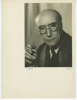 portrait photographique en buste d’André Gide, avec lunettes, de face, regardant vers le bas, une cigarette dans la main droite