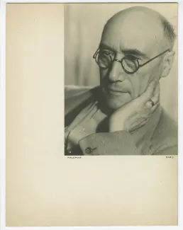 portrait photographique en gros plan d’André Gide, avec lunettes, de ¾ à gauche, regardant vers le bas, la main gauche sur la joue