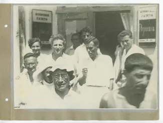 photographie de groupe devant les bureaux du journal Kourortnaya Gazeta, où l'on reconnaît André Gide, avec lunettes et chapeau à bords incurvés, Pierre Herbart au second plan, au centre, une cigarette dans la main droite, et Eugène Dabit, au premier rang