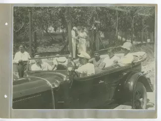 photographie montrant, assis à l'arrière d'une voiture décapotée, de gauche à droite, Eugène Dabit, Pierre Herbart et André Gide, avec chapeau, avec d'autres personnes, en extérieur, à Sotchi, lors du voyage en URSS, août 1936