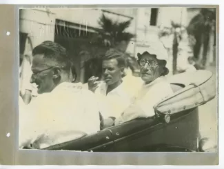 photographie d’André Gide, avec lunettes et chapeau, et Pierre Herbart, à l'arrière d'une voiture décapotée, avec d'autres personnes, en extérieur, à Sotchi, lors du voyage en URSS, août 1936