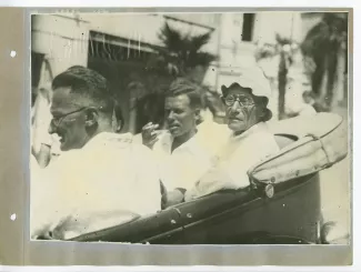 photographie d’André Gide, avec lunettes et chapeau, et Pierre Herbart, à l'arrière d'une voiture décapotée, avec d'autres personnes, en extérieur, à Sotchi, lors du voyage en URSS, août 1936