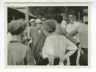 photographie montrant André Gide, avec lunettes et chapeau, Nina Mjedlova, l'interprète du couple Masereel, au premier plan, presque de dos, portant un béret, et devant elle Eugène Dabit, avec d'autres personnes, en extérieur, lors du voyage en URSS