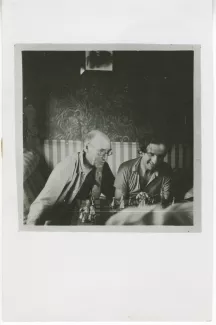 photographie d’André Gide, avec lunettes, et Louis Guilloux, jouant aux échecs, dans « le train vers Tiflis », lors du voyage en URSS, juillet 1936