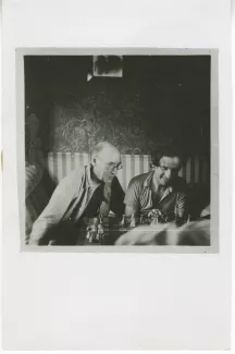 photographie d’André Gide, avec lunettes, et Louis Guilloux, jouant aux échecs, dans « le train vers Tiflis », lors du voyage en URSS, juillet 1936