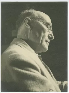 portrait photographique en buste d’André Gide, avec lunettes et foulard fleuri, de profil à droite, en contre-plongée, au Vaneau