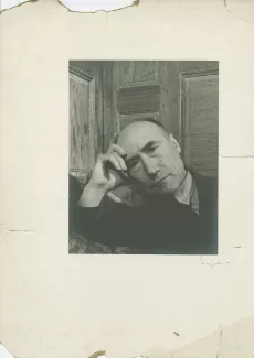 portrait photographique en buste d’André Gide, accoudé à un sofa, la tête appuyée sur la main droite, au Vaneau