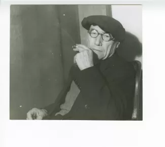 portrait photographique en buste d’André Gide, avec lunettes et béret, fumant, mars 1944