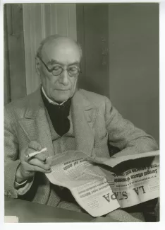 portrait photographique d’André Gide, avec lunettes, lisant le journal italien La Stampa, novembre 1947