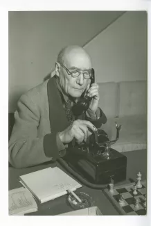 portrait photographique d’André Gide, avec lunettes, en train de téléphoner, chez Richard Heyd, hiver 1947