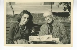 photographie d’André Gide, avec lunettes, tenant un numéro du journal Combat, et Catherine Gide, tous deux assis sur un banc, 3 avril 1947
