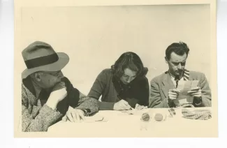 photographie d’André Gide, avec lunettes et chapeau, Catherine Gide et Jean Lambert, autour d'une table, avril 1947