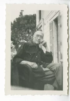 photographie d’André Gide, avec lunettes, assis sur une terrasse d'immeuble, après sa sortie de la clinique du Belvédère à Nice, été 1949