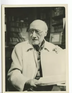 portrait photographique en buste d’André Gide, avec lunettes, tenant un grand cahier, au Vaneau ; photographie de plateau du film La vie commence demain de Nicole Védrès