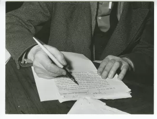 photographie des mains d’André Gide, annotant une lettre dactylographiée à la plume, au Vaneau, février 1950 ; reportage pour Paris-Match