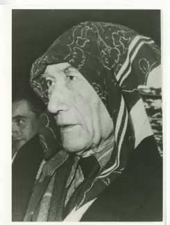 photographie en gros plan d’André Gide, avec un foulard sur la tête, lors d'une séance de cinéma