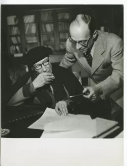 photographie d’André Gide, avec lunettes et béret, et son neveu Dominique Drouin, regardant ensemble un document, au Vaneau, lors du tournage du film Avec André Gide de Marc Allégret, janvier 1951 ; reportage pour Paris-Match