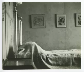 photographie du lit dans la chambre d'André Gide, avec les pastels de Simon Bussy accrochés au mur, après sa mort, au Vaneau